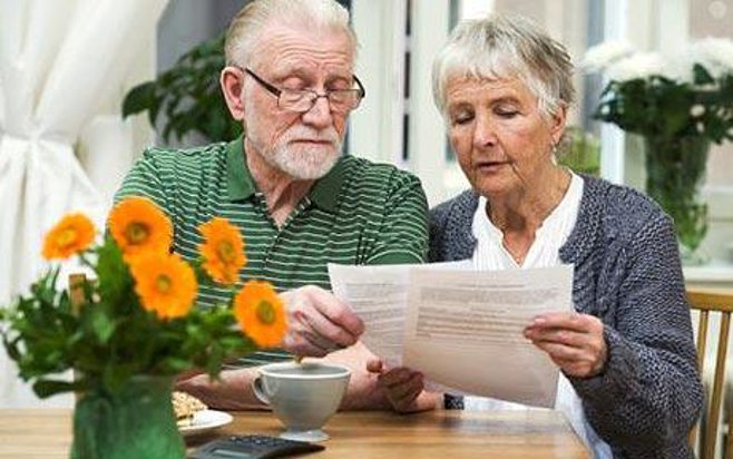 elderlyCouple reading papers. alert1 mediccal alert systems